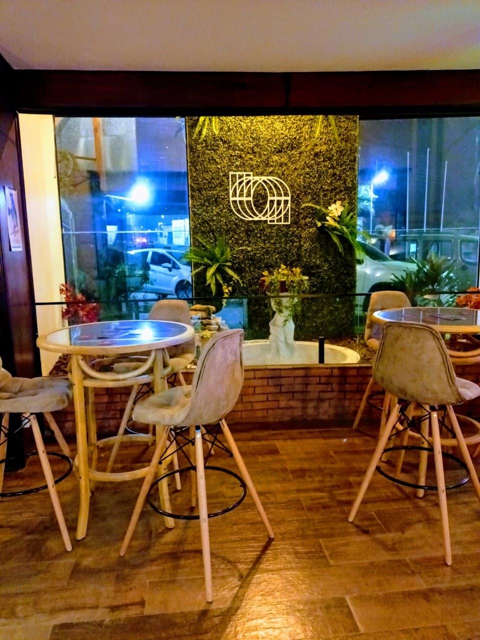 Um restaurante com mesas e cadeiras em frente a uma janela.