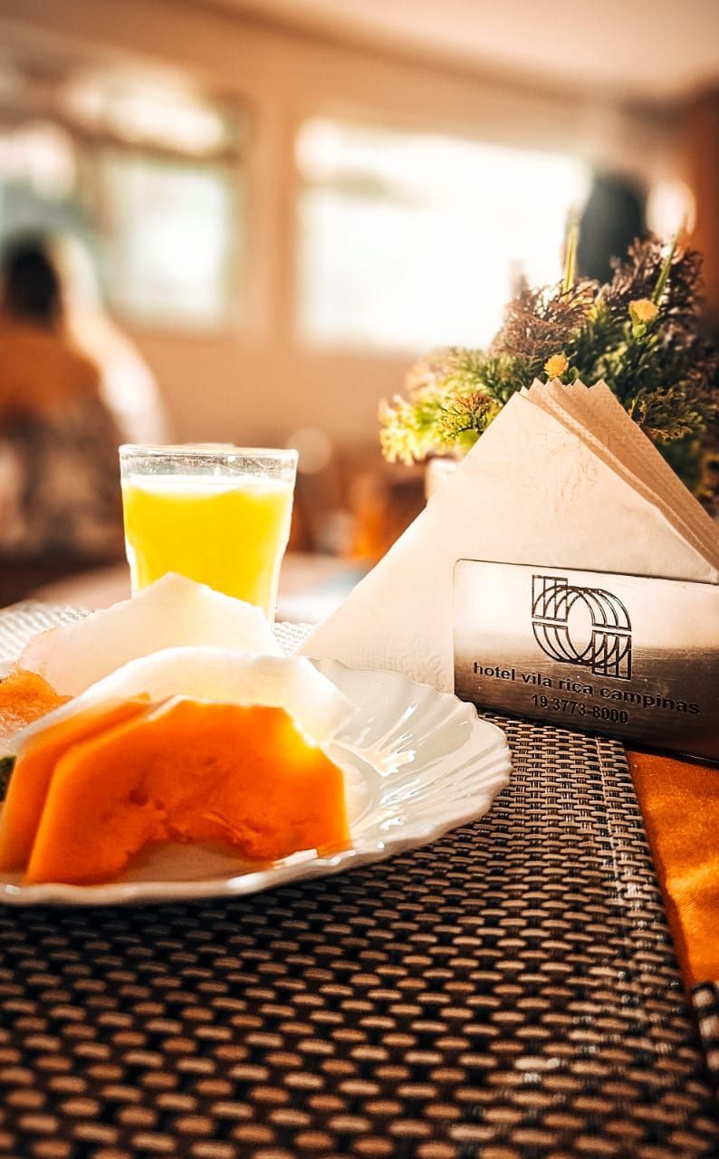 Um prato de comida e um copo de suco de laranja sobre uma mesa.