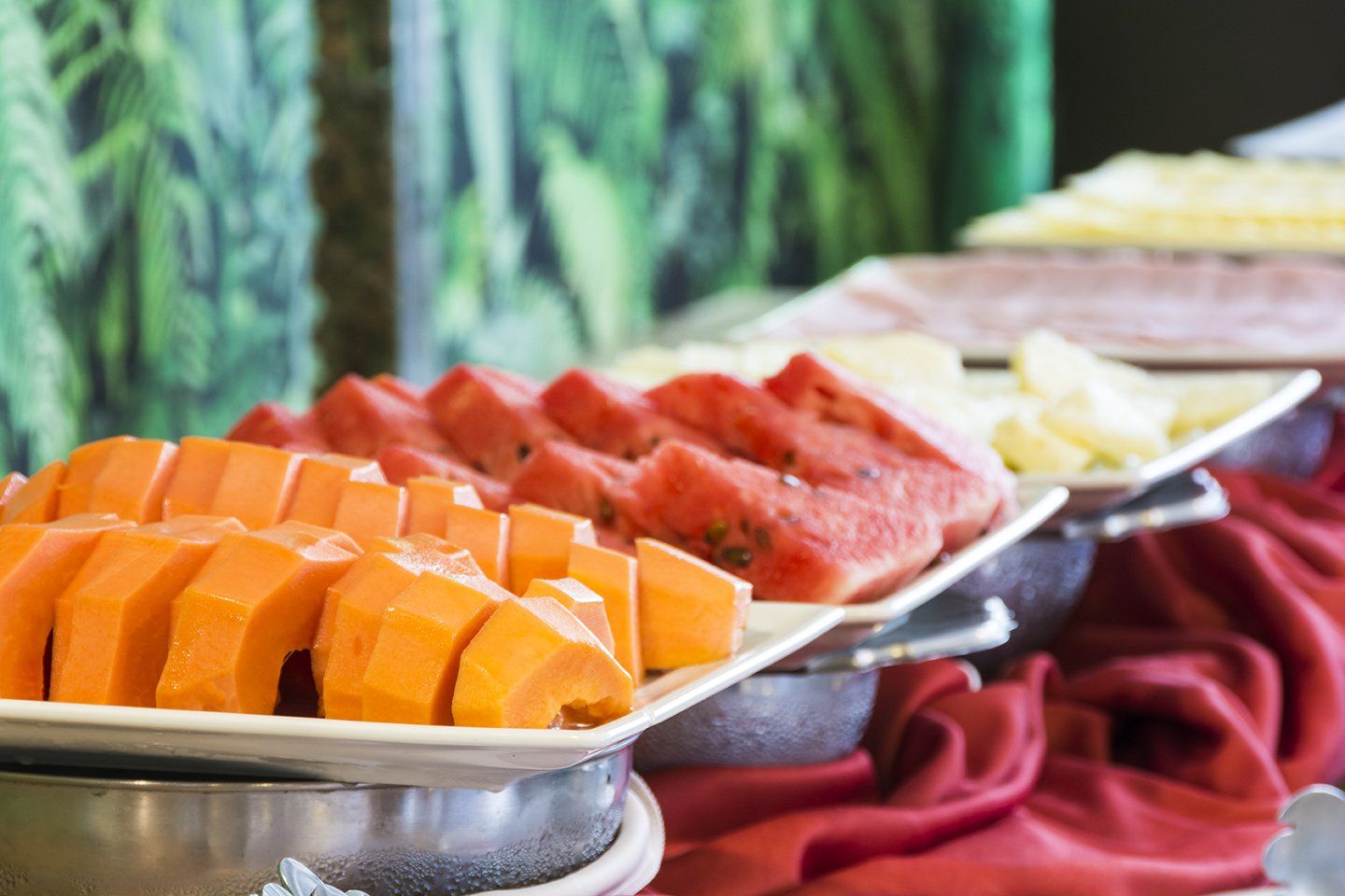 Uma bandeja de fatias de melancia e mamão sobre uma mesa.