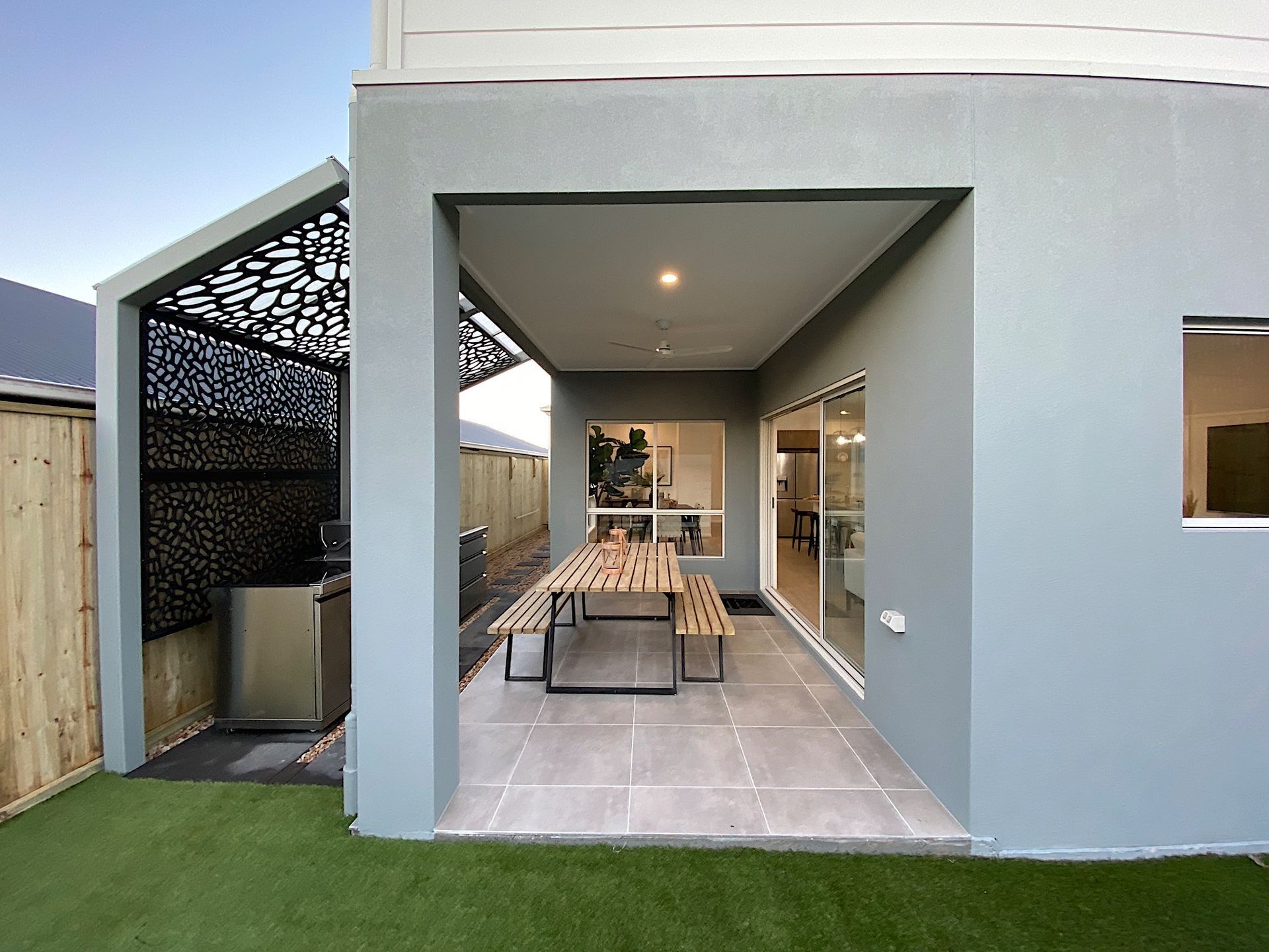 Cozy living room with a white couch, round coffee table, and sliding glass doors leading to a backyard.