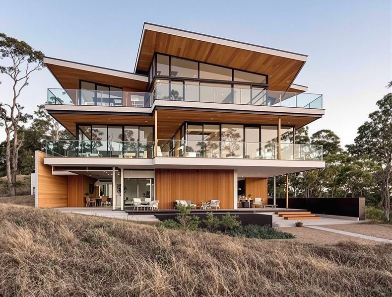 Modern multi-story house with wood siding, glass windows, and angled roof, in a natural setting.