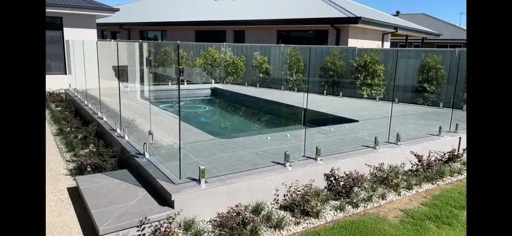 Modern white house with a swimming pool reflecting the blue sky.