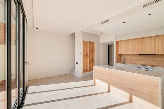 An empty kitchen with wooden cabinets and sliding glass doors.