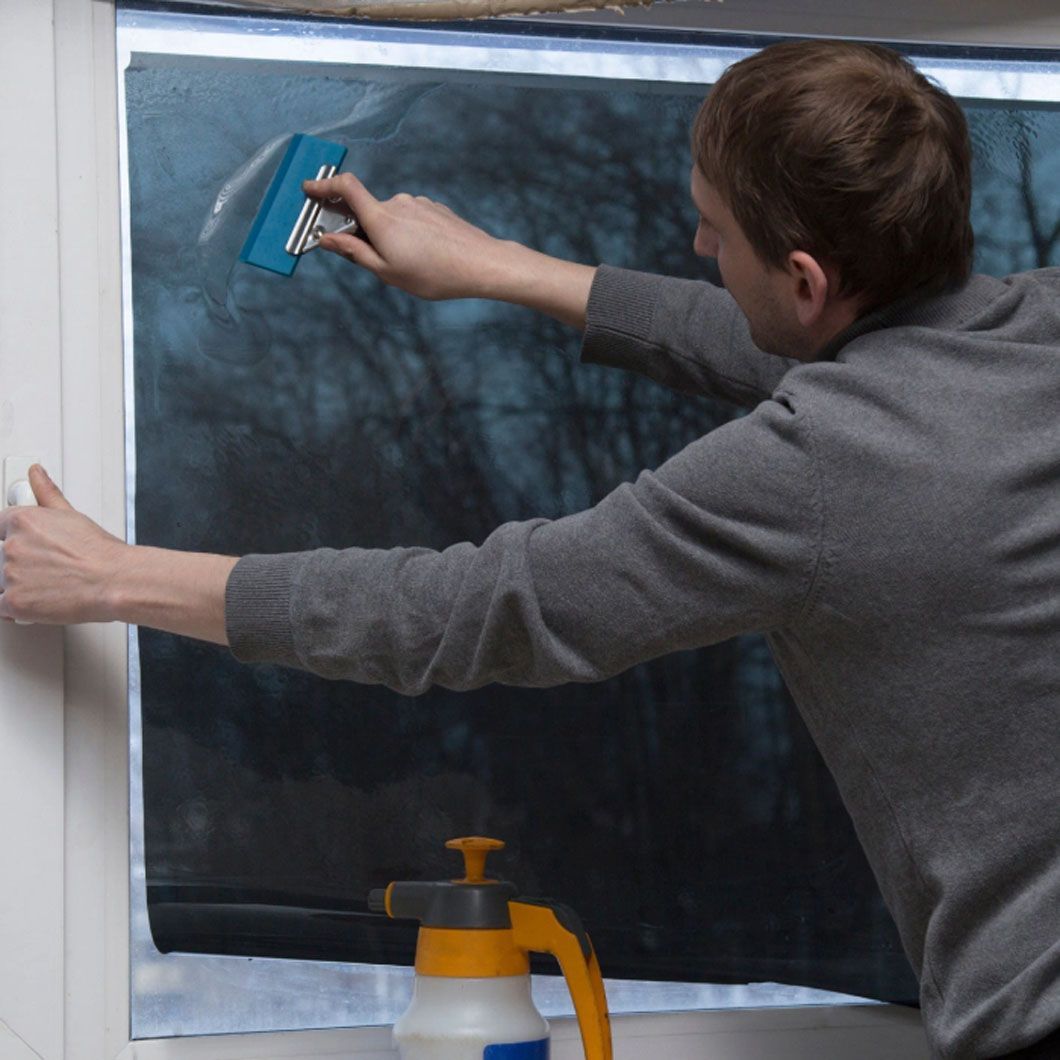 A man is cleaning a window with a squeegee