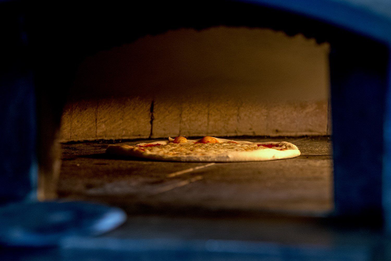 Pizza infornata nel forno a legna