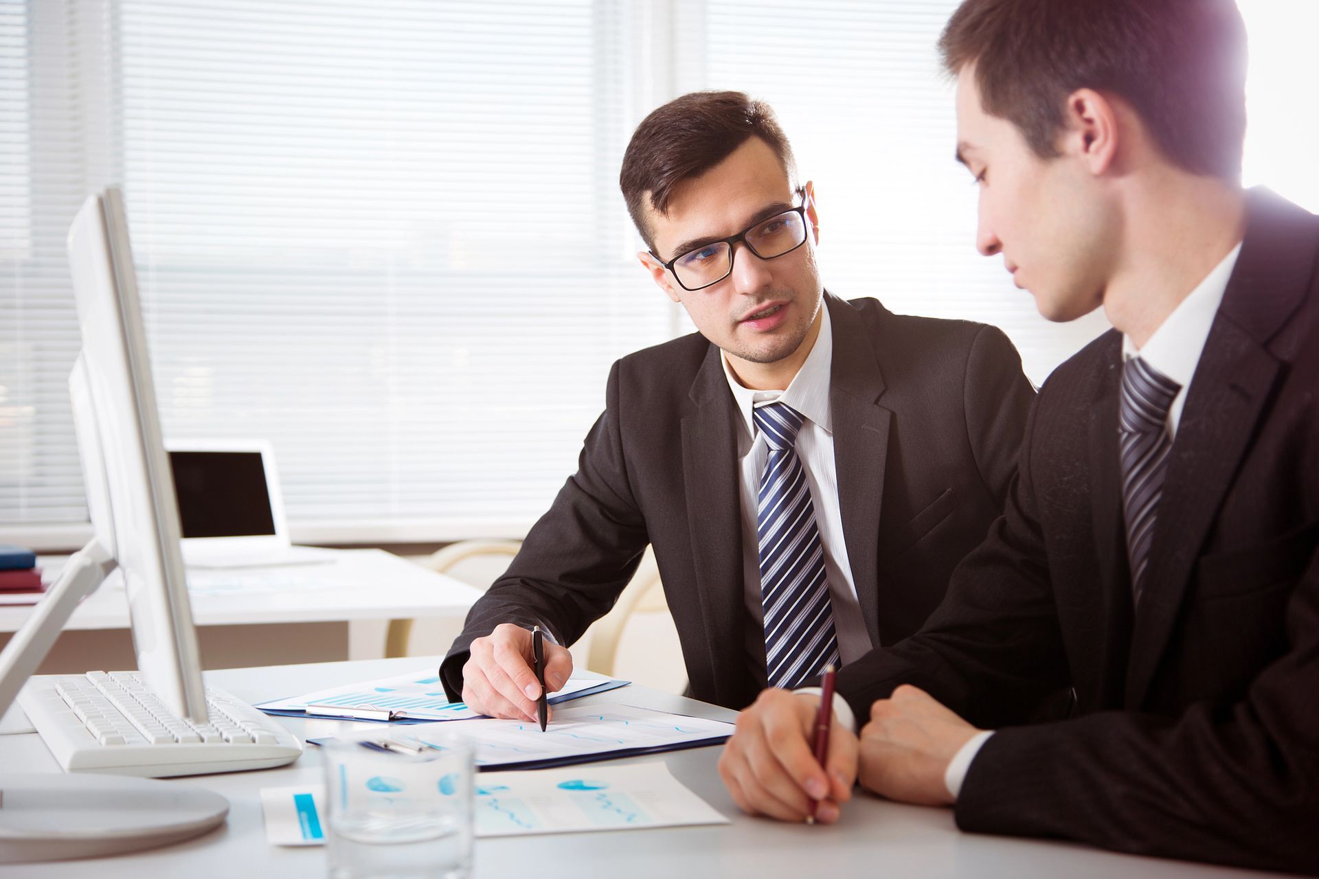 Dos mujeres están sentadas en sillas hablando entre sí.
