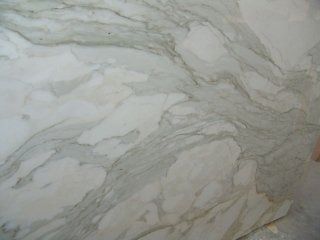 Lastra di marmo bianco caratterizzata da venature fluide, delicate e grigie, che percorrono tutta la superficie.