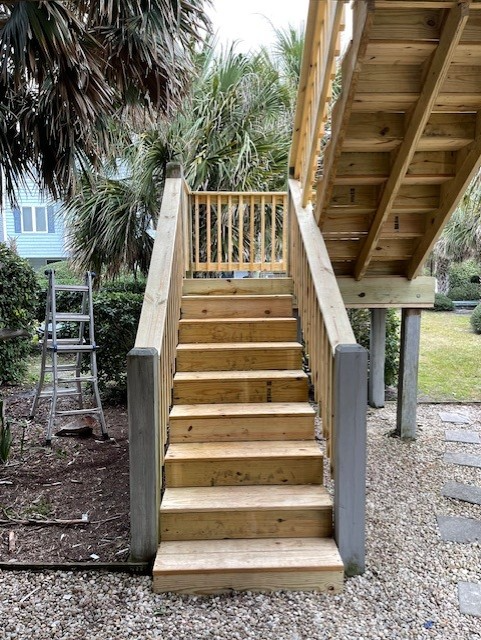 Wooden outdoor staircase with gate leading to an elevated deck. Wooden outdoor staircase with gate leading to an elevated deck.