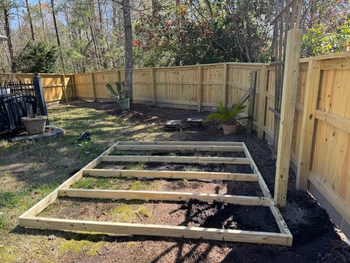 Construction workers building a wooden structure under a blue sky, using tools.