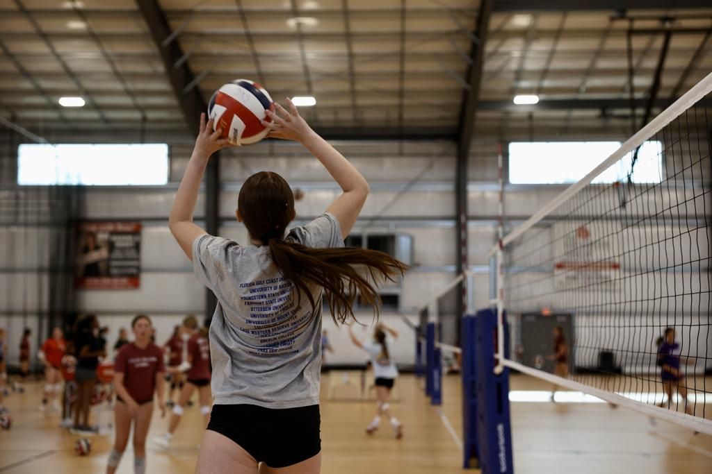A young girl is playing volleyball in a gym.