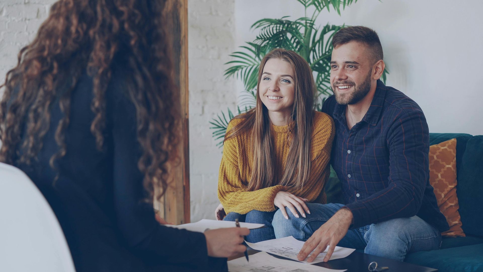 Two people smiling on a couch during a 상담 session with a therapist across from them