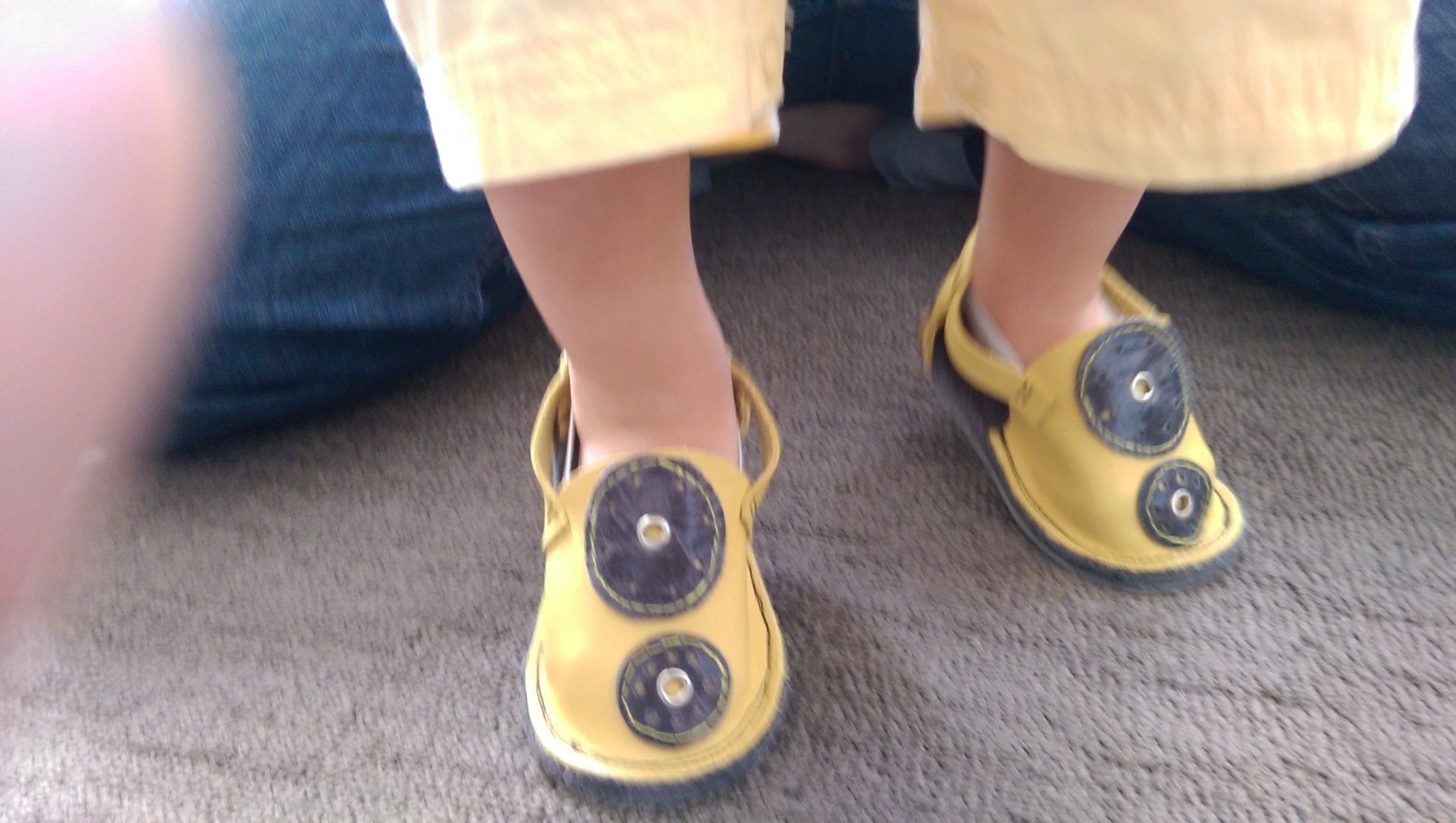 baby walking wearing yellow gray leather hub vitalsole baby shoes lower half  of child's body skin exposed on ankles child wearing yellow shorts