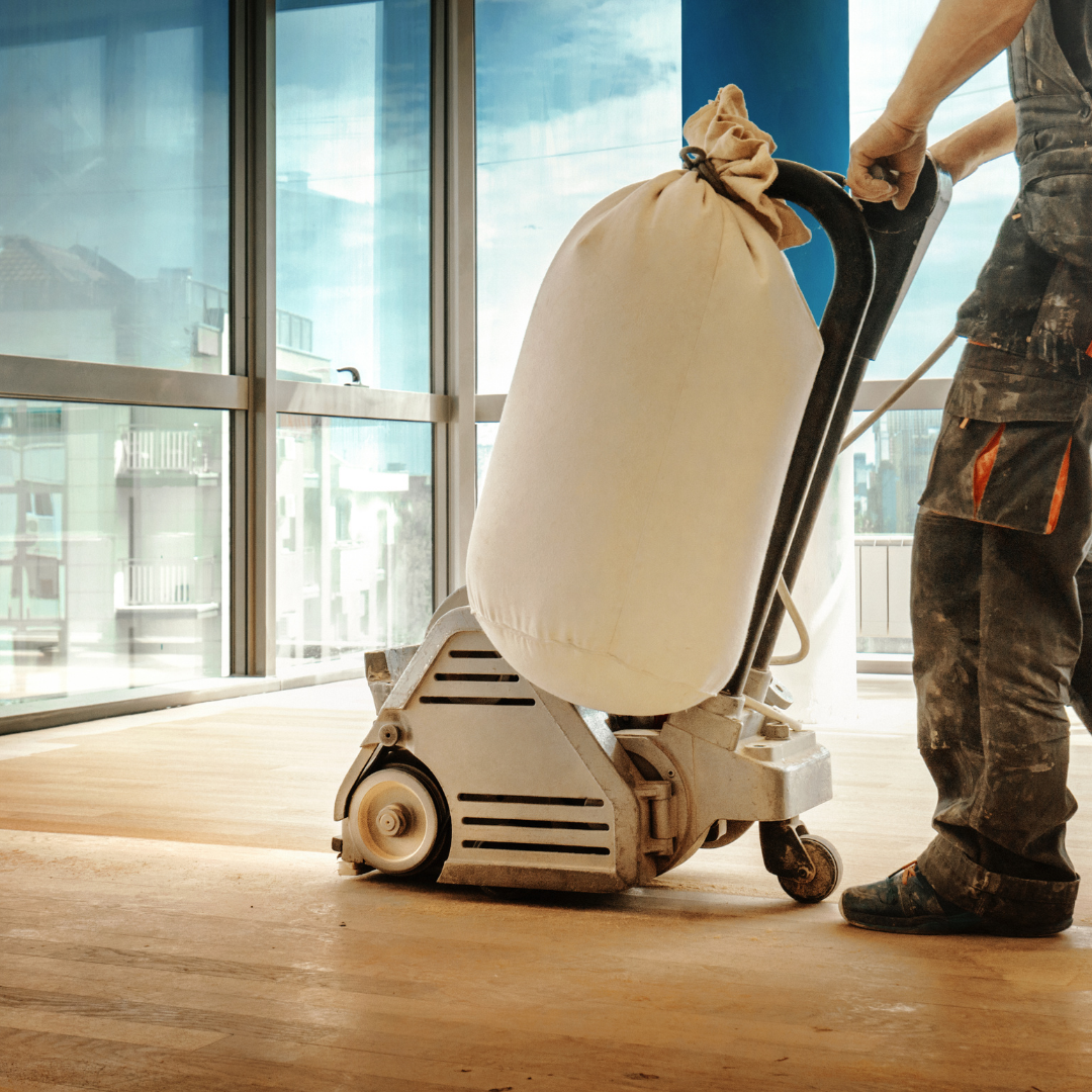 A Man Refinishing A Hardwood Floor