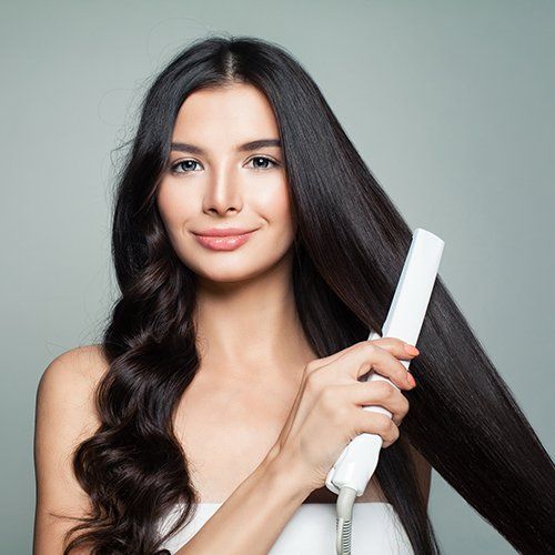 Woman With Curly Hair And Long Straight Hair Using Hair Straightener — Los Angeles, CA — Isis Hair Salon