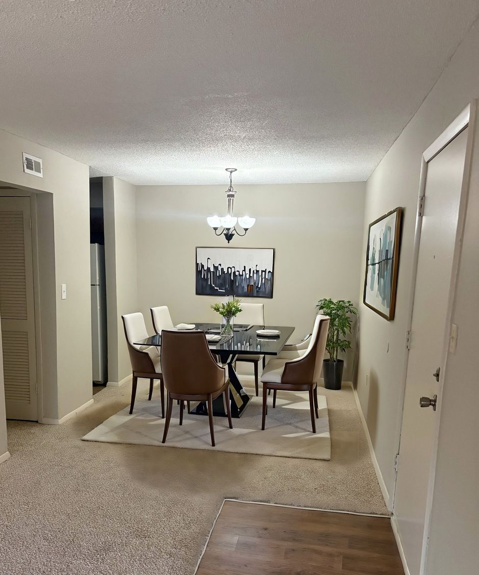 A dining room with a table and chairs and a chandelier.