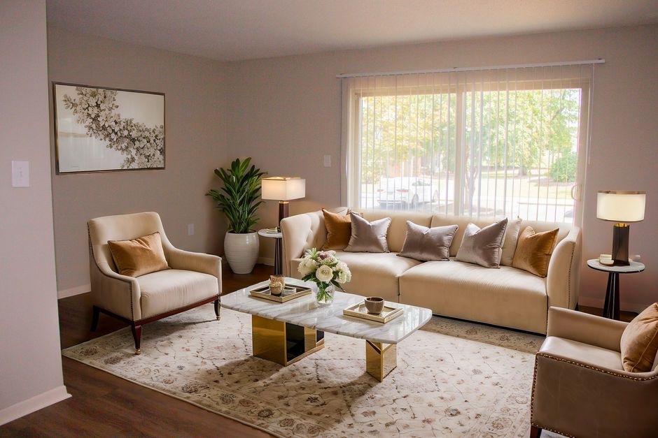 A living room with a couch , chairs , and a coffee table.
