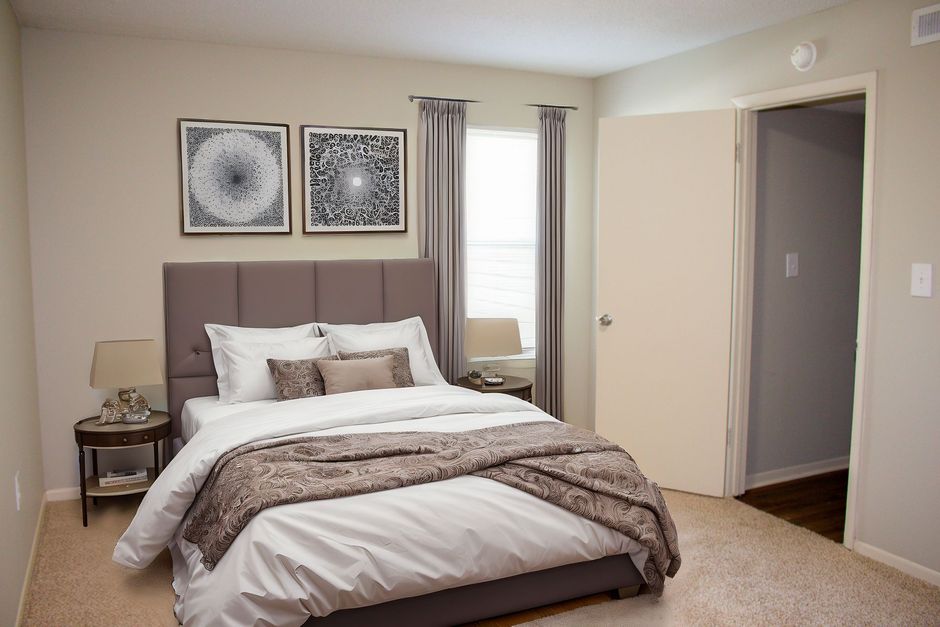 A bedroom with a large bed and a window.