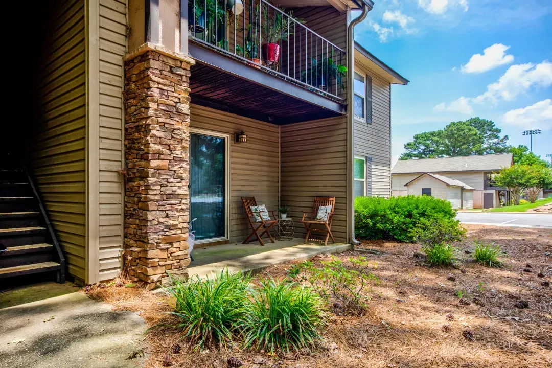 There is a balcony with chairs and a table on it.