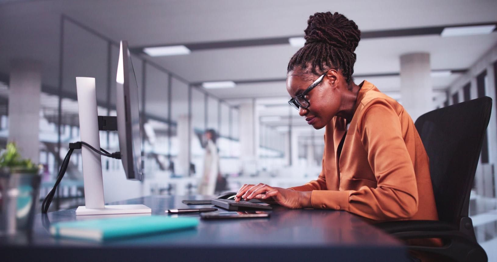 Person sitting at desk with poor posture compared to proper ergonomic posture highlighting spinal alignment.