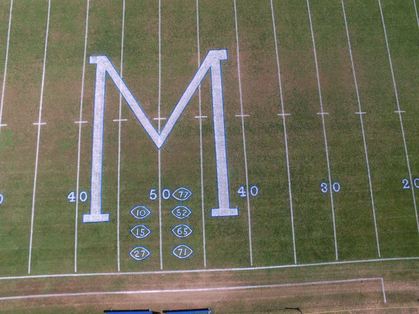 A football field with the letter m painted on it