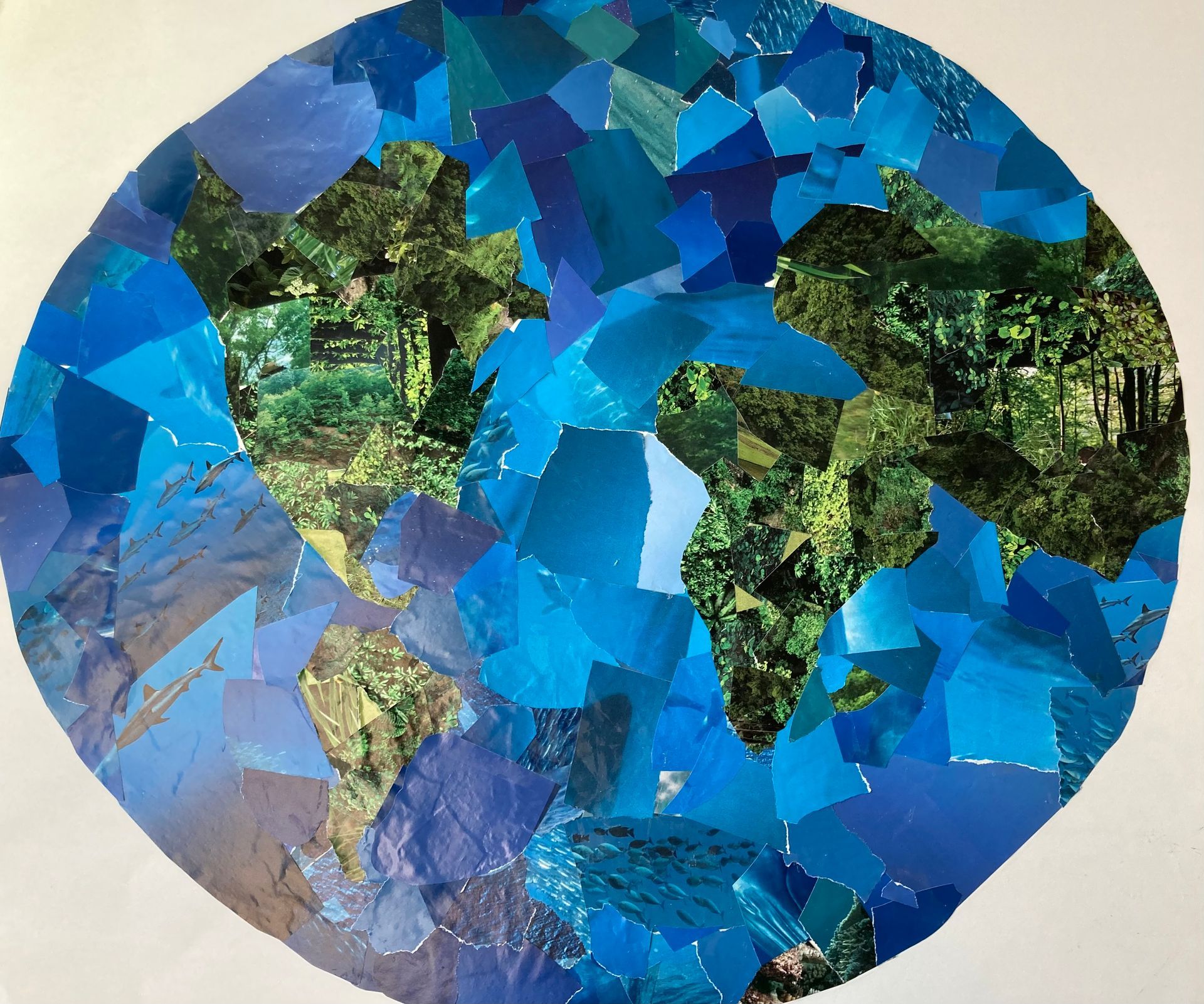 A collage of a globe made of blue pieces of paper