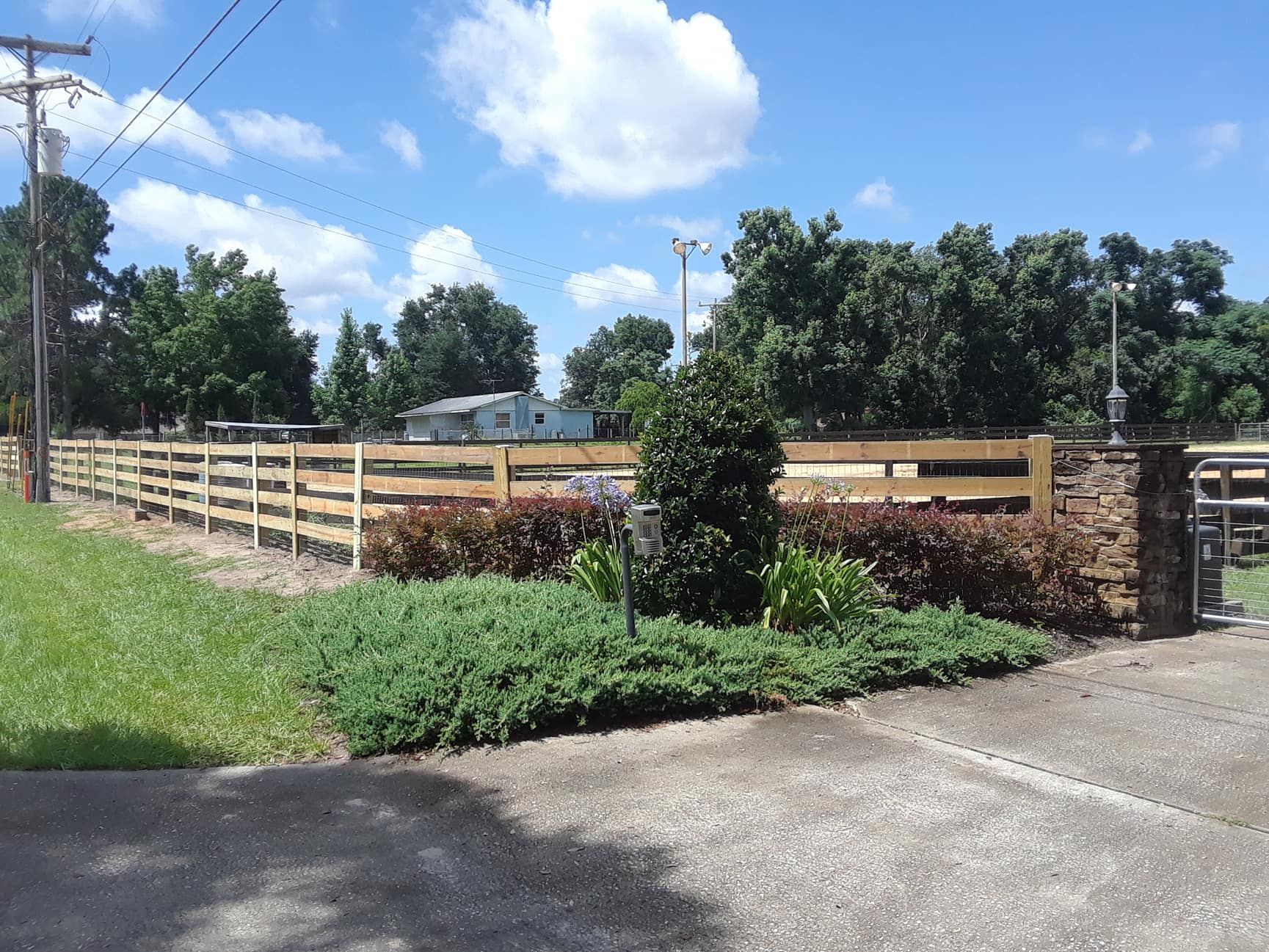 A wooden fence surrounds a lush green field