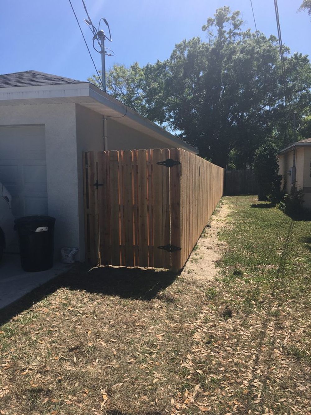 A wooden fence with a gate in the backyard of a house.