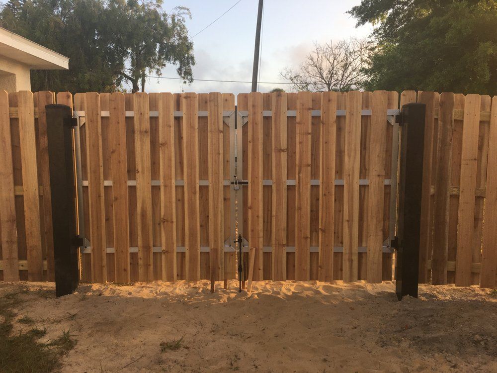 A wooden fence with a gate in the middle of it