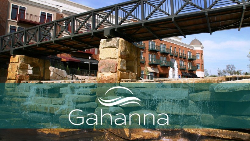 Gahanna, Ohio: Stone waterfall and bridge in a park, with a brick building in the background. Gahanna, Ohio: Stone waterfall and bridge in a park, with a brick building in the background.