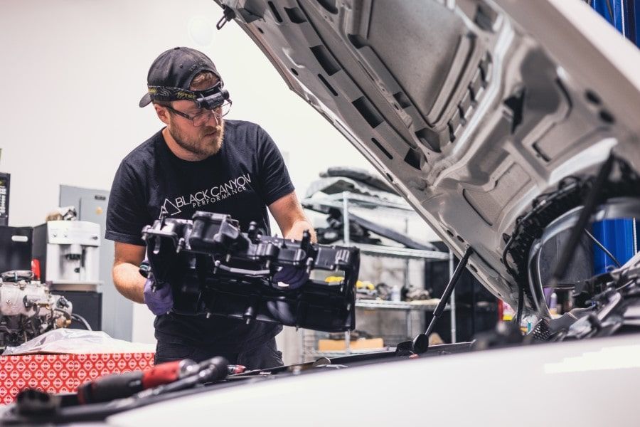 Technician Working Under Car Hood