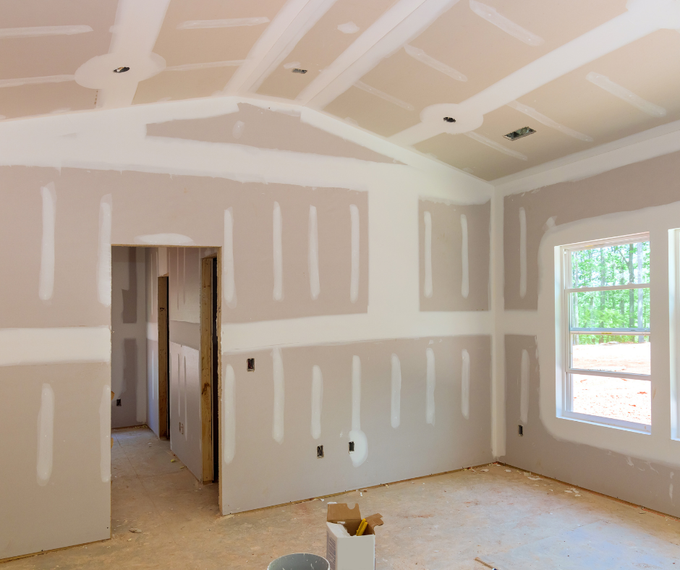 An empty room with drywall on the walls and ceiling.
