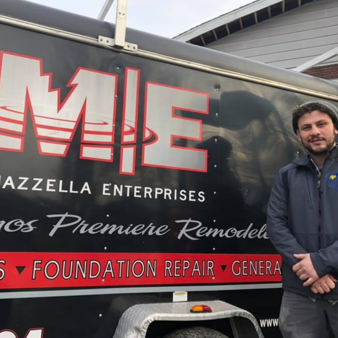 A man is standing in front of a truck that says mie