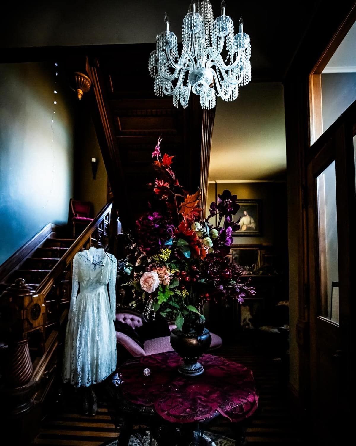 A room with a staircase and a table with flowers on it