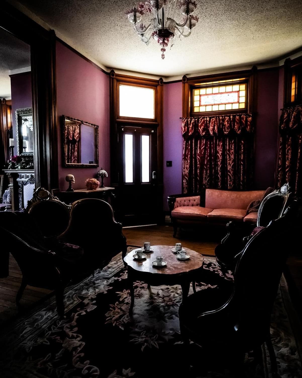 A living room with purple walls and a chandelier
