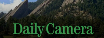 A daily camera logo with a mountain in the background
