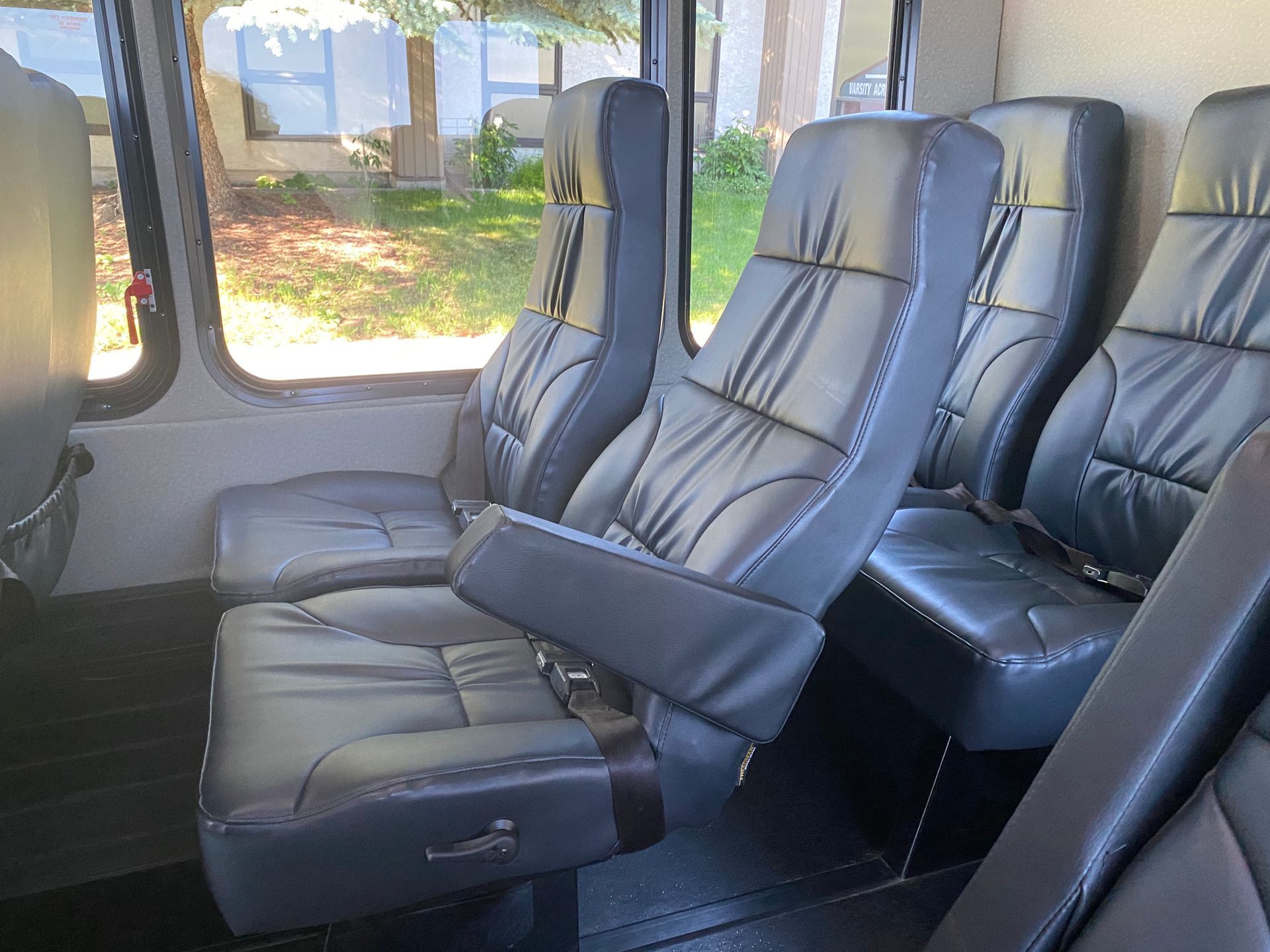 the inside of a 24 passenger executive shuttle bus showing detail of seats and a window .