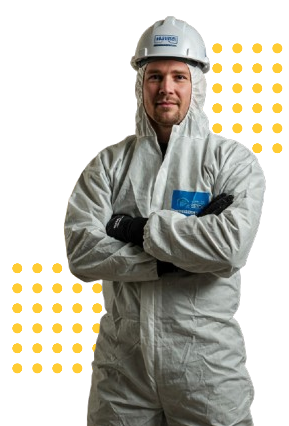 A man in a protective suit and hard hat is standing with his arms crossed.