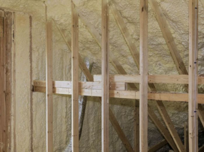 A room with wooden beams and foam insulation on the walls.