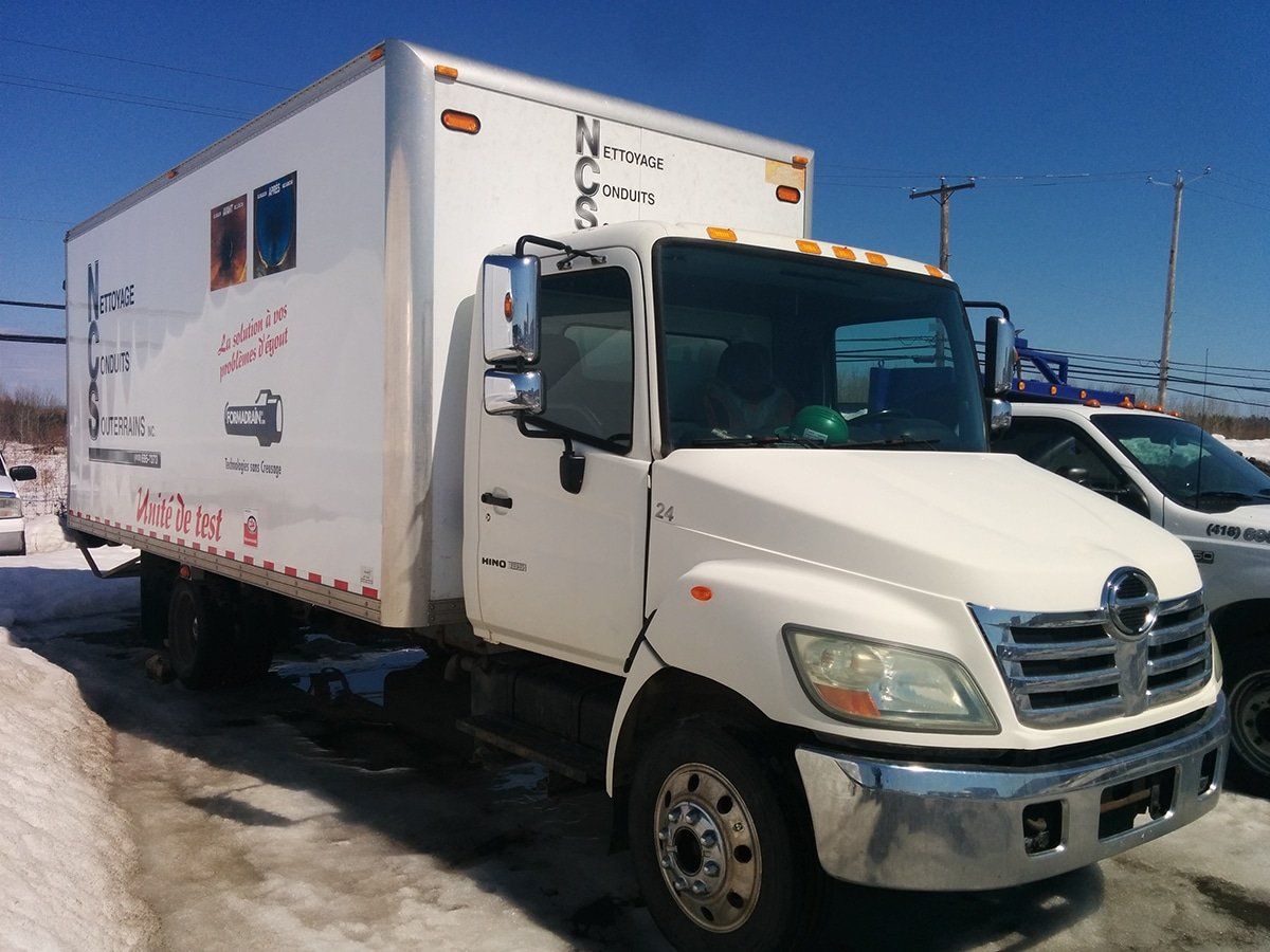 Un camion blanc est garé dans la neige