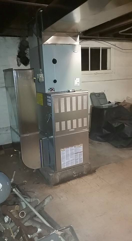 A heater is sitting in a basement next to a window in Chicago.