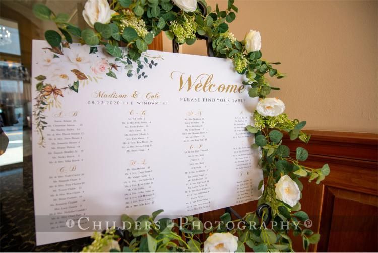 Wedding seating chart decorated with flowers, on an easel.