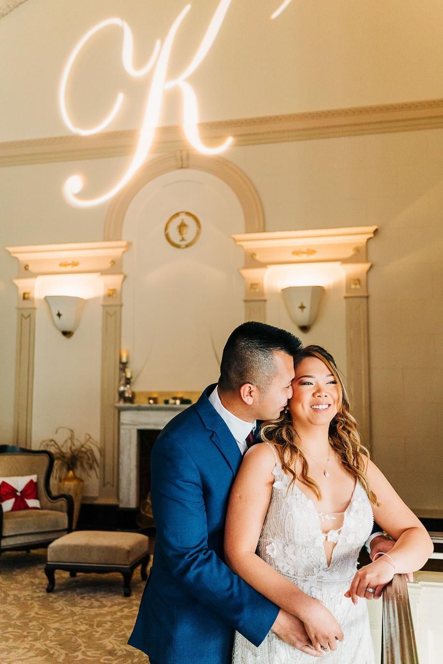 Couple embraces indoors; the man in blue jacket kisses the woman's cheek, 