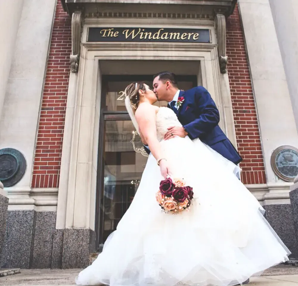 Wedding pricing pamphlet cover: Couple kissing in front of 