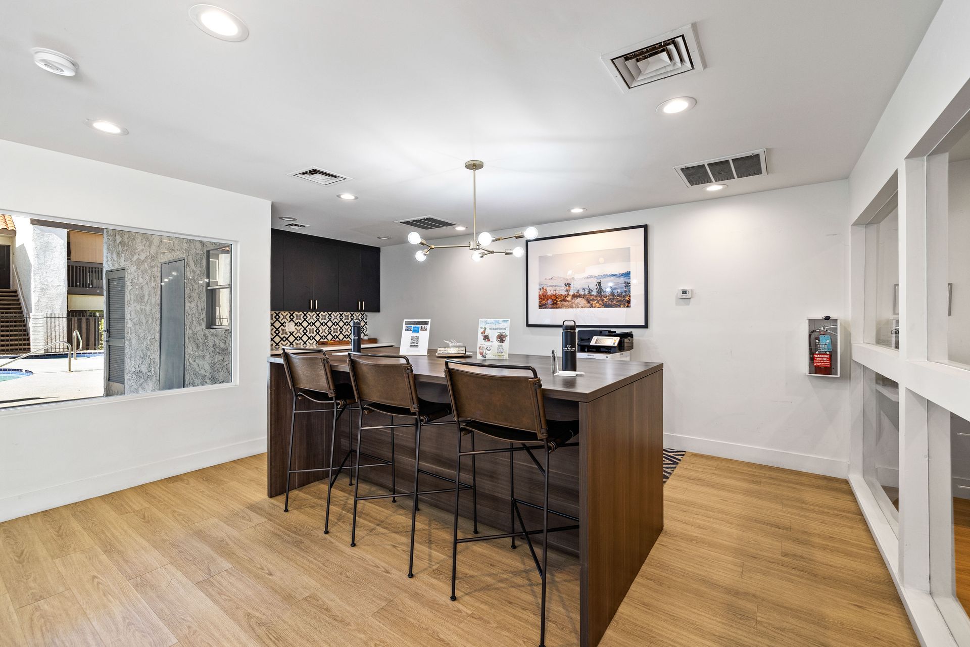 Modern kitchen with counter seating, wood floors, and minimalist decor.