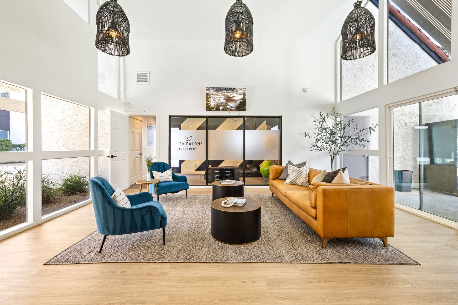 Lounge area with high ceilings, large windows, and colorful furniture.
