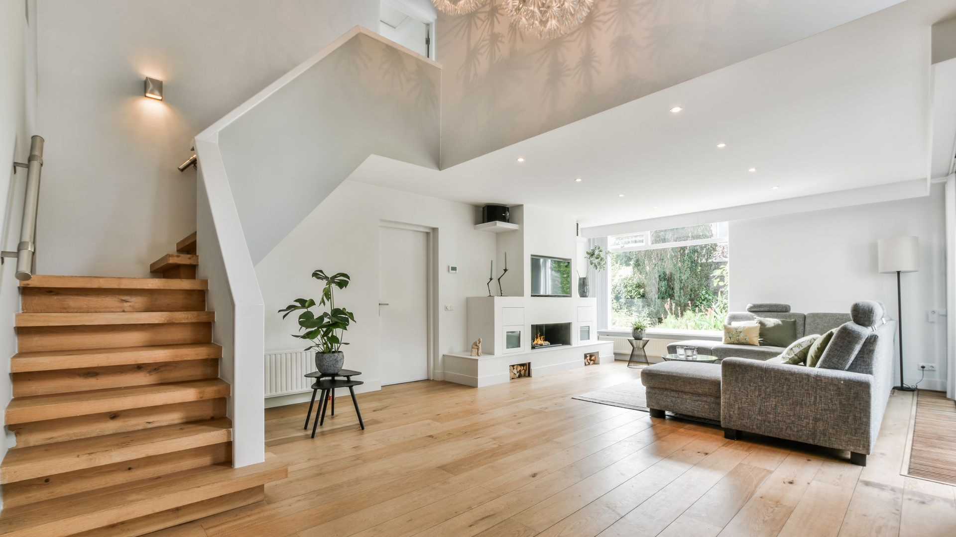 A living room with a wooden staircase leading up to the second floor.