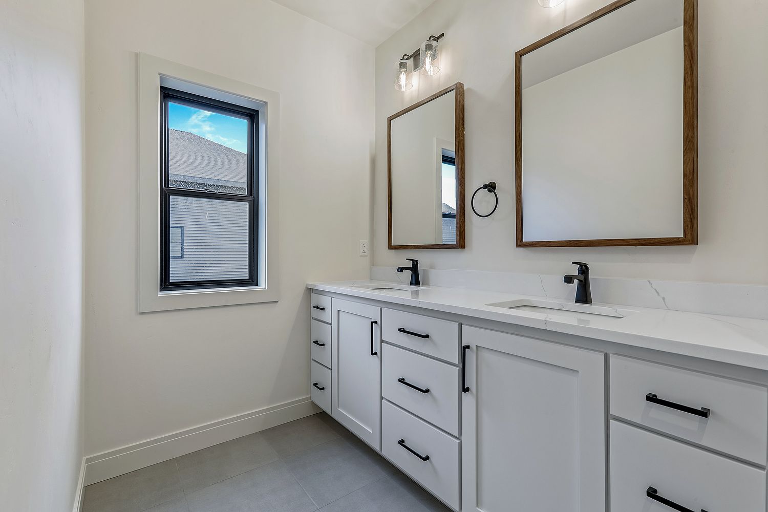 A bathroom with two sinks and two mirrors.