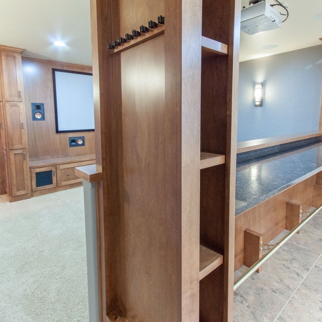 A wooden shelf in a room with a projector screen