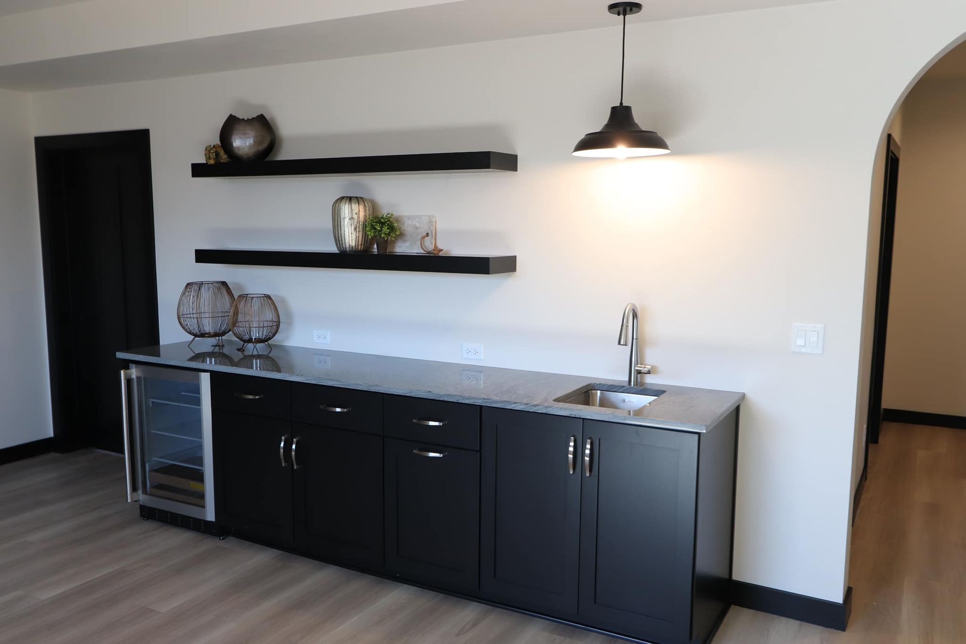 A kitchen with black cabinets and a sink