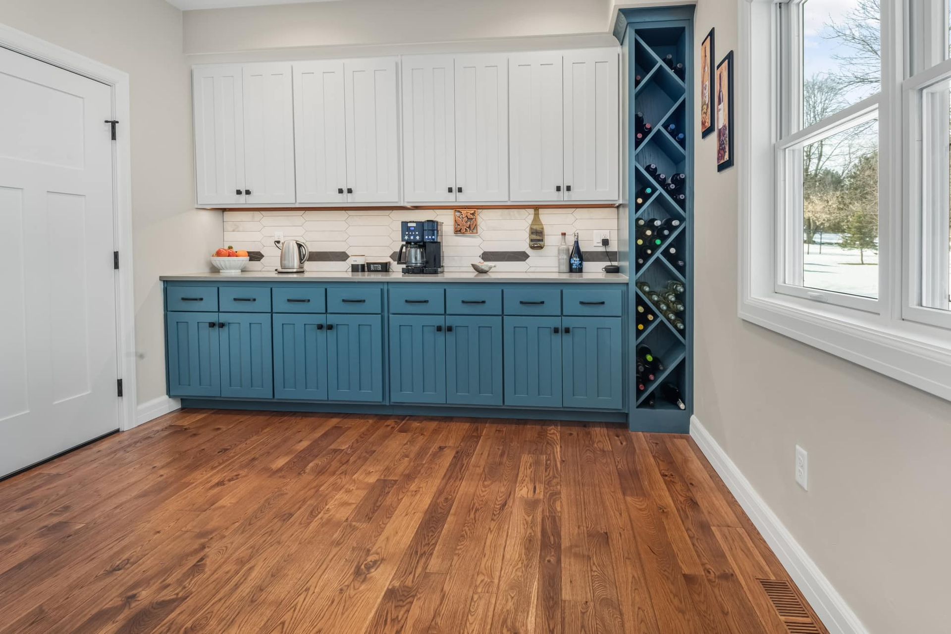 A kitchen with blue cabinets and a wine rack.